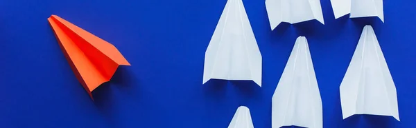 Верхний вид белых и красных бумажных самолетов на синем фоне, концепция лидерства, панорамный снимок — стоковое фото