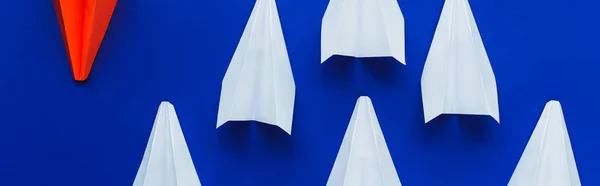 Vista superior de aviões de papel branco e vermelho em fundo azul, conceito de liderança, tiro panorâmico — Fotografia de Stock