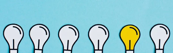 Flat lay com lâmpadas de papel no fundo azul, conceito de negócio — Fotografia de Stock