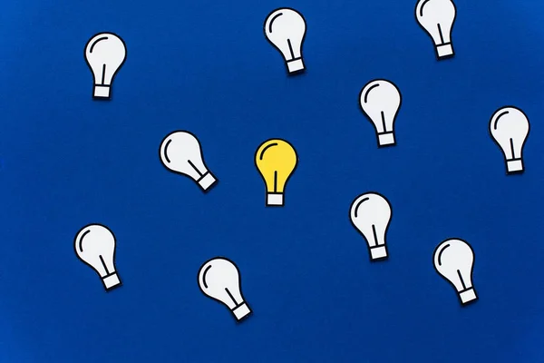 Top view of paper light bulbs on blue background, business concept — Stock Photo