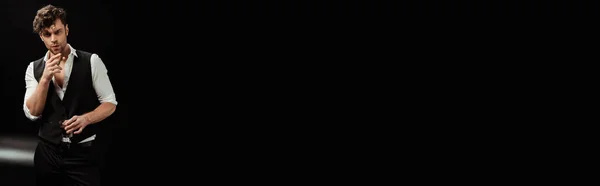 Панорамний знімок людини, що тримає келих віскі та сигари на чорному тлі — стокове фото