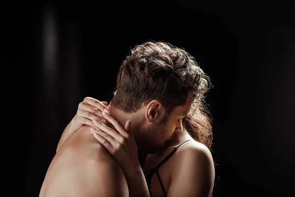 Woman hugging shirtless boyfriend on black background — Stock Photo