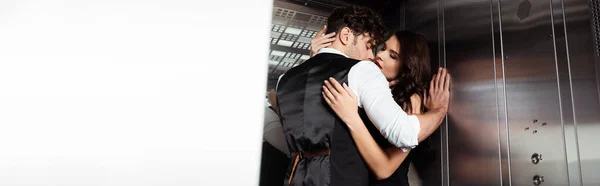 Colpo panoramico di uomo in panciotto baciare fidanzata in ascensore — Foto stock