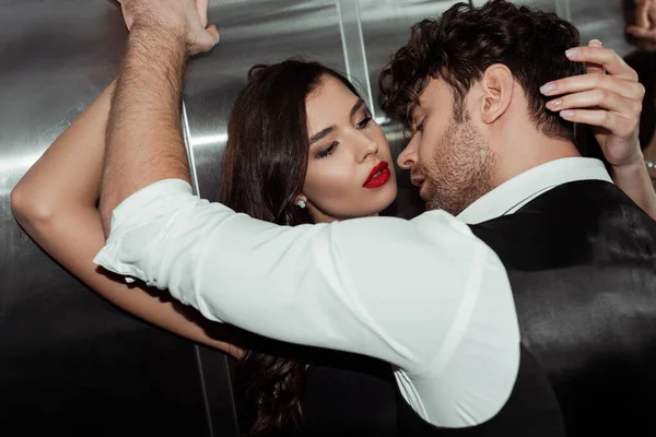 Homem bonito em camisa e colete perto de mulher atraente com lábios vermelhos no elevador — Fotografia de Stock