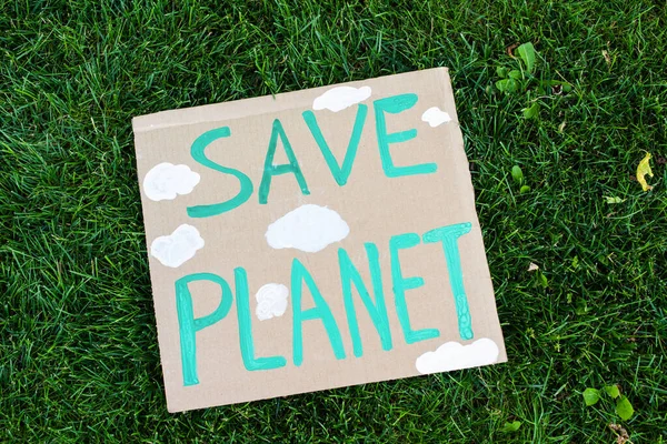 Top view of placard with save planet lettering on green grass, ecology concept — Stock Photo