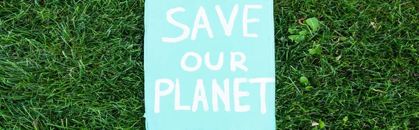 Horizontales Plakatkonzept mit Rettet unseren Planeten Schriftzug auf Gras, Ökologiekonzept — Stockfoto