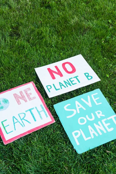 Vista ad alto angolo di cartelli senza pianeta b, salvare la nostra pialla e una scritta terra su erba, concetto di ecologia — Foto stock