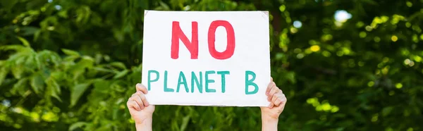 Horizontal crop of man holding placard with no planet b words with trees at background, ecology concept — Stock Photo