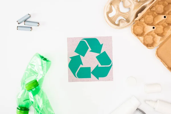Ansicht von Plastikflaschen, Karton-Eierschale und Akkumulatoren in Kartennähe mit Recycling-Sing auf weißem Hintergrund, ökologisches Konzept — Stockfoto