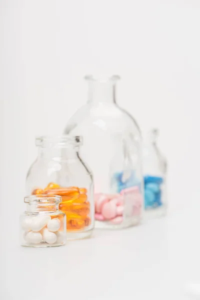 Selective focus of pills in glass bottles on white background — Stock Photo