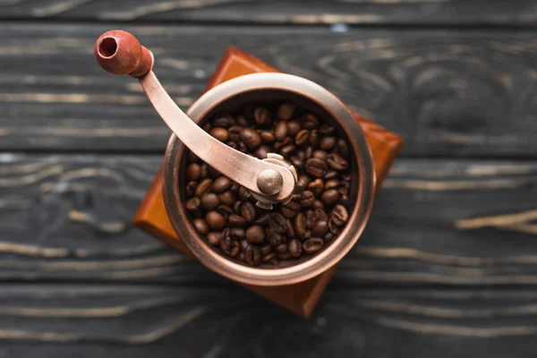 Foco seletivo de moedor de café vintage com grãos de café na superfície de madeira — Fotografia de Stock