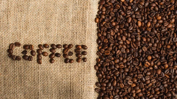 Vista dall'alto della scritta di caffè fatta di fagioli su sacco — Foto stock