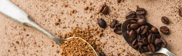 Vista dall'alto di caffè solubile e fagioli in cucchiai su superficie beige, colpo panoramico — Foto stock