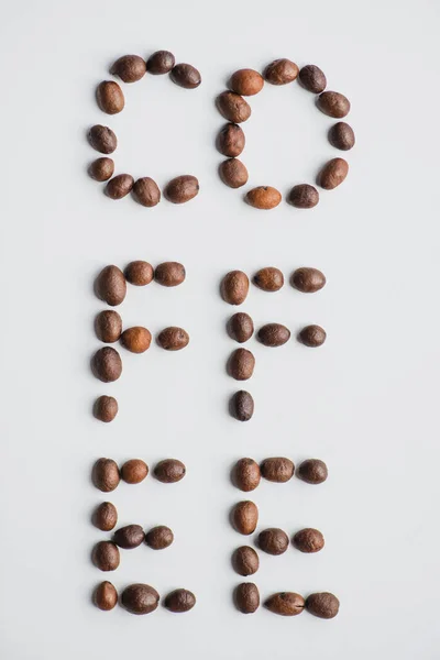 Draufsicht auf Kaffee-Schriftzug aus Bohnen auf weißer Oberfläche — Stockfoto