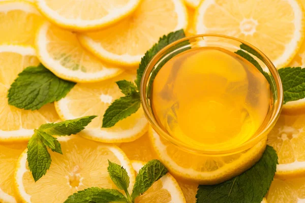 Tarro de miel en rodajas de limones amarillos con hojas verdes menta - foto de stock