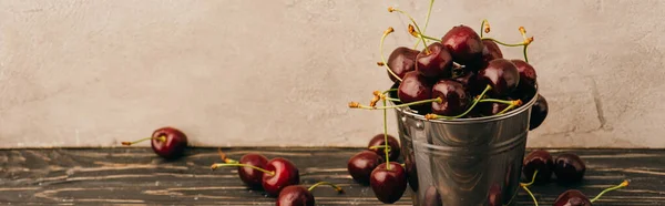 Cerejas doces maduras molhadas em balde de metal na superfície de madeira, tiro panorâmico — Fotografia de Stock