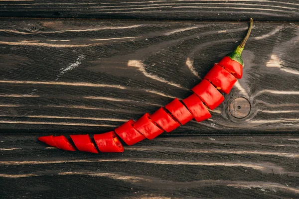 Top view of sliced red chili pepper on wooden surface — Stock Photo