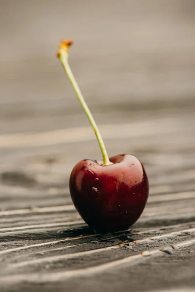 Close up view of wet ripe sweet cherry on wooden surface — Stock Photo