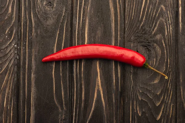 Top view of spicy red chili pepper on wooden surface — Stock Photo