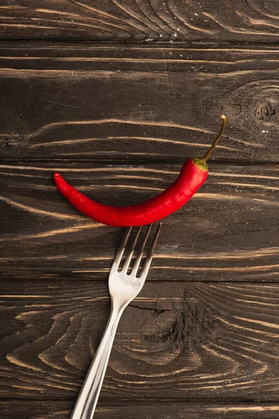 Draufsicht auf scharfe rote Chilischote auf Gabel auf Holzoberfläche — Stockfoto