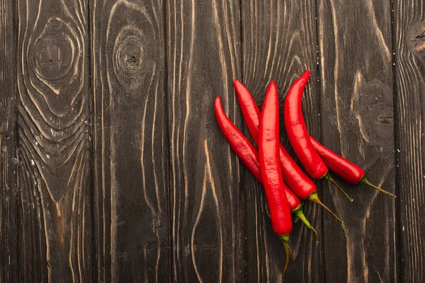 Top view of chili peppers on wooden surface — Stock Photo