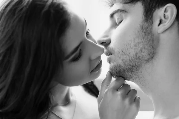 Black and white shot of sexy couple kissing at home — Stock Photo