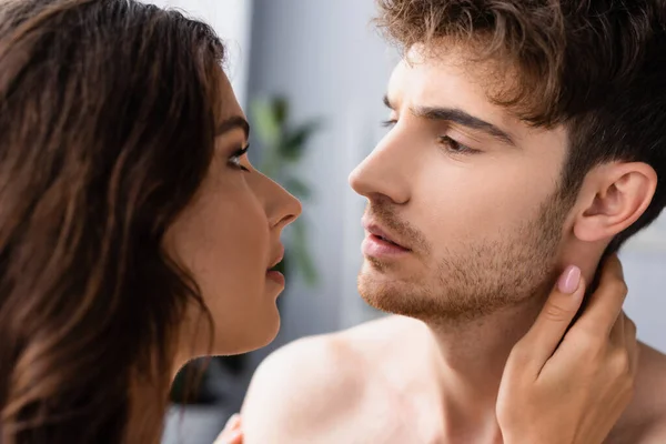 Selective focus of shirtless man looking at brunette girlfriend — Stock Photo