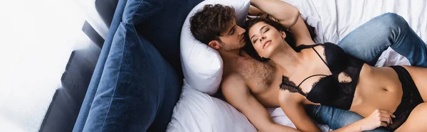 Vue de dessus du couple sexy couché sur le lit, panoramique — Photo de stock