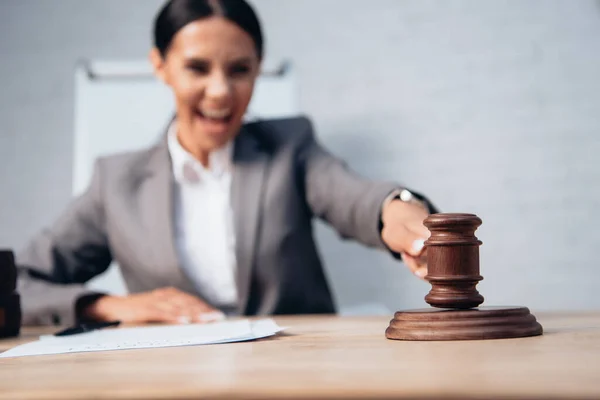 Selective focus of excited judge holding wooden gavel — Stock Photo