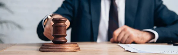 Horizontal crop of man holding gavel near papers on table — Stock Photo