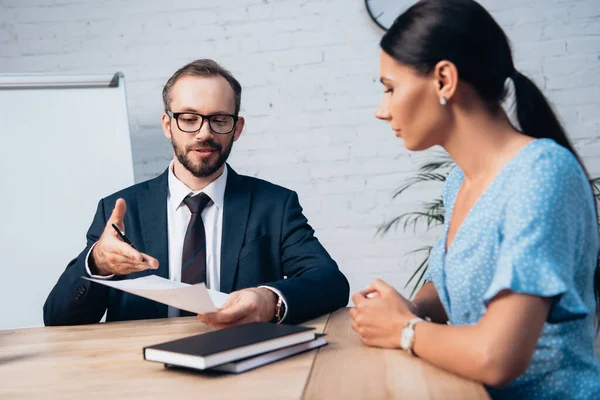 Selektiver Fokus des bärtigen Rechtsanwalts mit Brille, der mit der Hand auf Dokumente in der Nähe seines Mandanten zeigt — Stockfoto