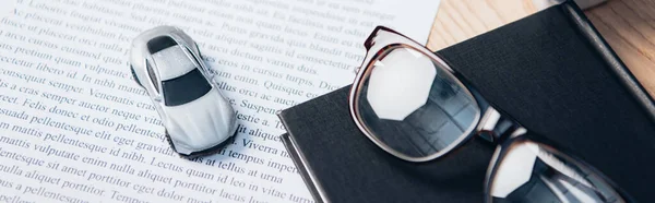 Image horizontale de la voiture jouet sur contrat d'assurance près de portable et lunettes — Photo de stock