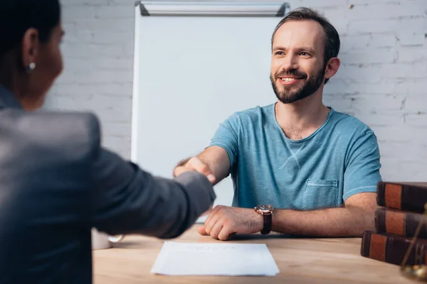 Selective focus of bearded client shaking hands with lawyer — Stock Photo