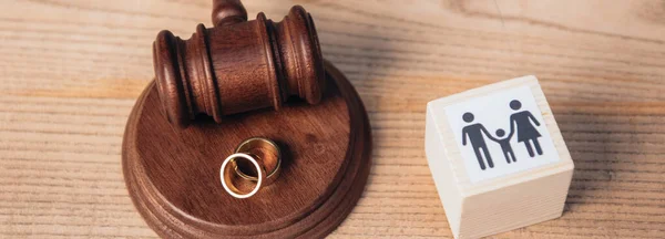 Panoramic concept of golden rings on wooden gavel near cube with family — Stock Photo