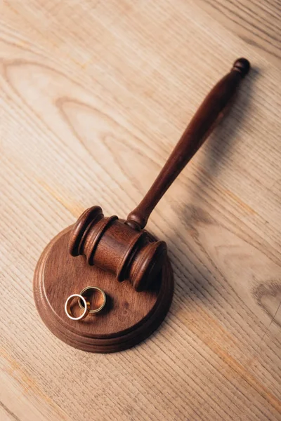 Vista superior de anéis dourados no martelo de madeira, conceito de divórcio — Fotografia de Stock