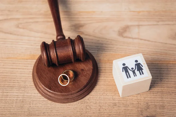 Vista superior de anéis dourados no martelo perto do cubo de madeira com a família, conceito do divórcio — Fotografia de Stock