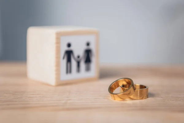 Foco seletivo de anéis dourados perto de cubo de madeira com a família — Fotografia de Stock