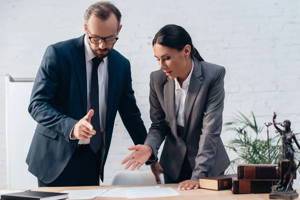 Selective focus of lawyer pointing with hand at document near bearded businessman in office — Stock Photo