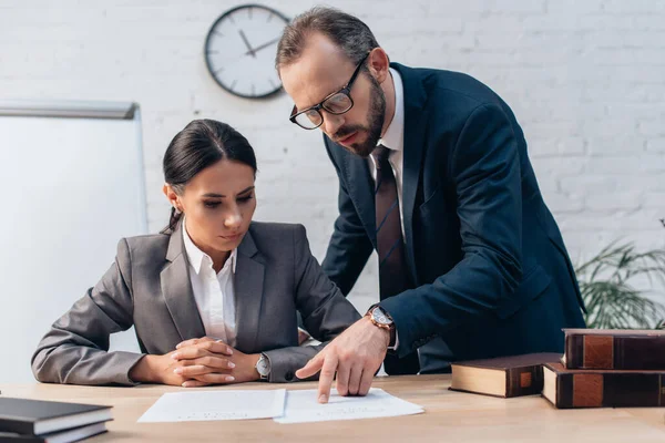 Selective focus of lawyer pointing with finger near documents and businesswoman — Stock Photo