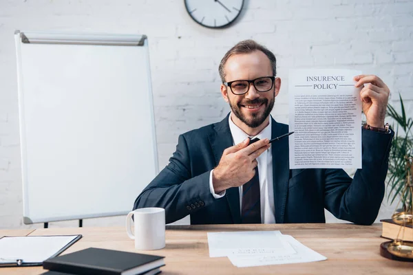 Messa a fuoco selettiva di avvocato in bicchieri che tengono penna e contratto con polizza di assicurazione lettering in ufficio — Foto stock