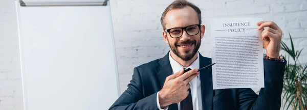 Colheita horizontal de advogado em óculos segurando caneta e contrato com a apólice de seguro lettering no escritório — Fotografia de Stock