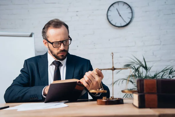Selective focus of bearded lawyer in suit reading book in office — Stock Photo