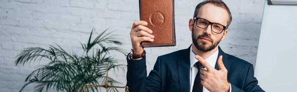 Website header of bearded lawyer pointing with finger at book — Stock Photo