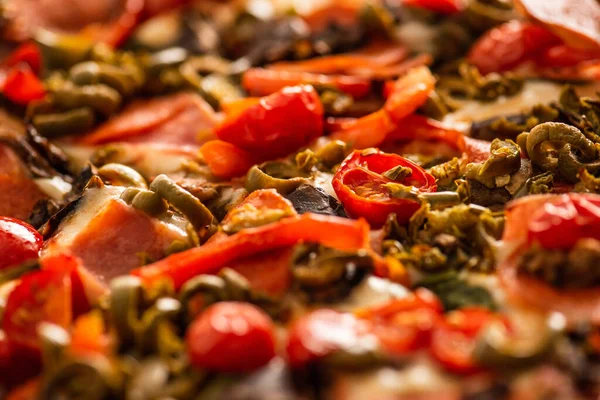 Закрываем глаза на вкусную итальянскую пиццу с овощами и салями — стоковое фото