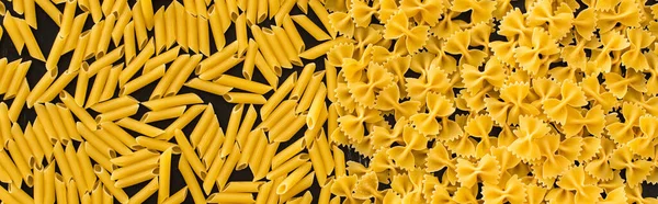 Top view of raw penne and farfalle pasta, panoramic shot — Stock Photo