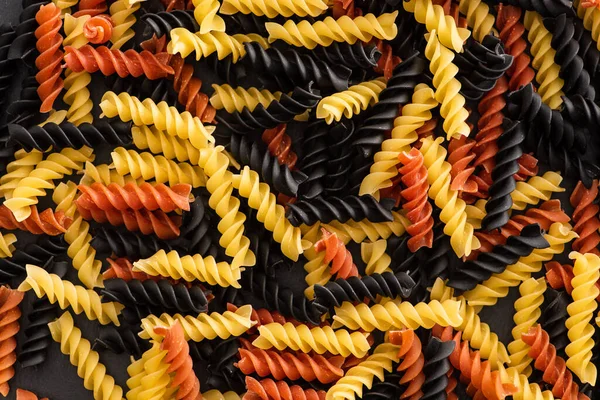 Vista superior de pasta de fusilli de colores crudos - foto de stock