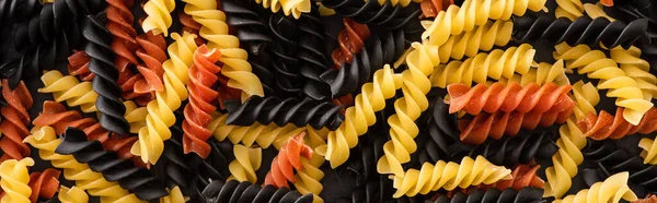 Vista dall'alto di pasta fusilli colorata cruda, colpo panoramico — Foto stock