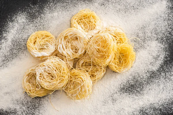 Vue du dessus des pâtes crues Capellini dans la farine — Photo de stock