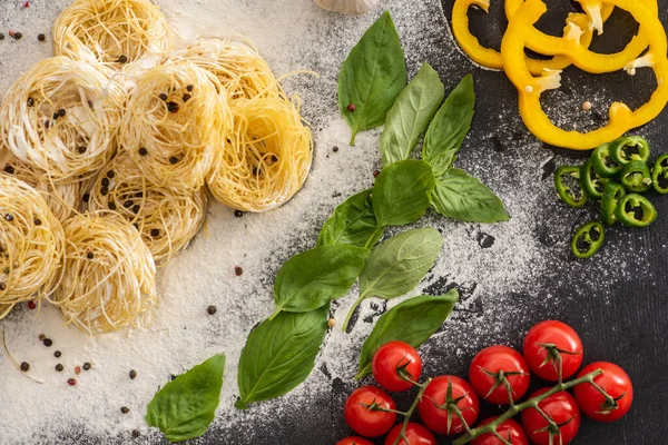 Top view of raw Capellini with vegetables, spices and flour — Stock Photo