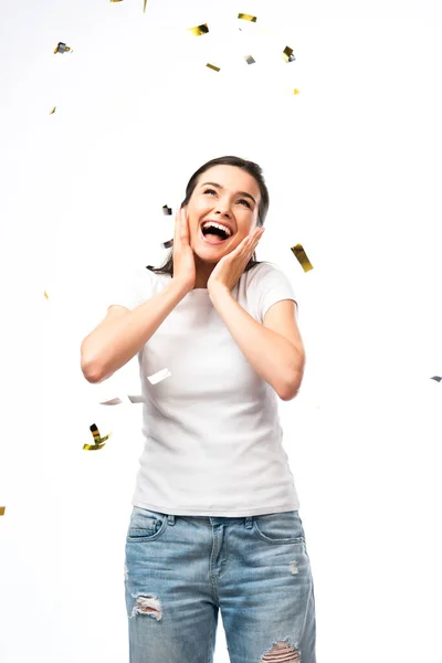 Mujer excitada en camiseta blanca de pie cerca de confeti en blanco - foto de stock